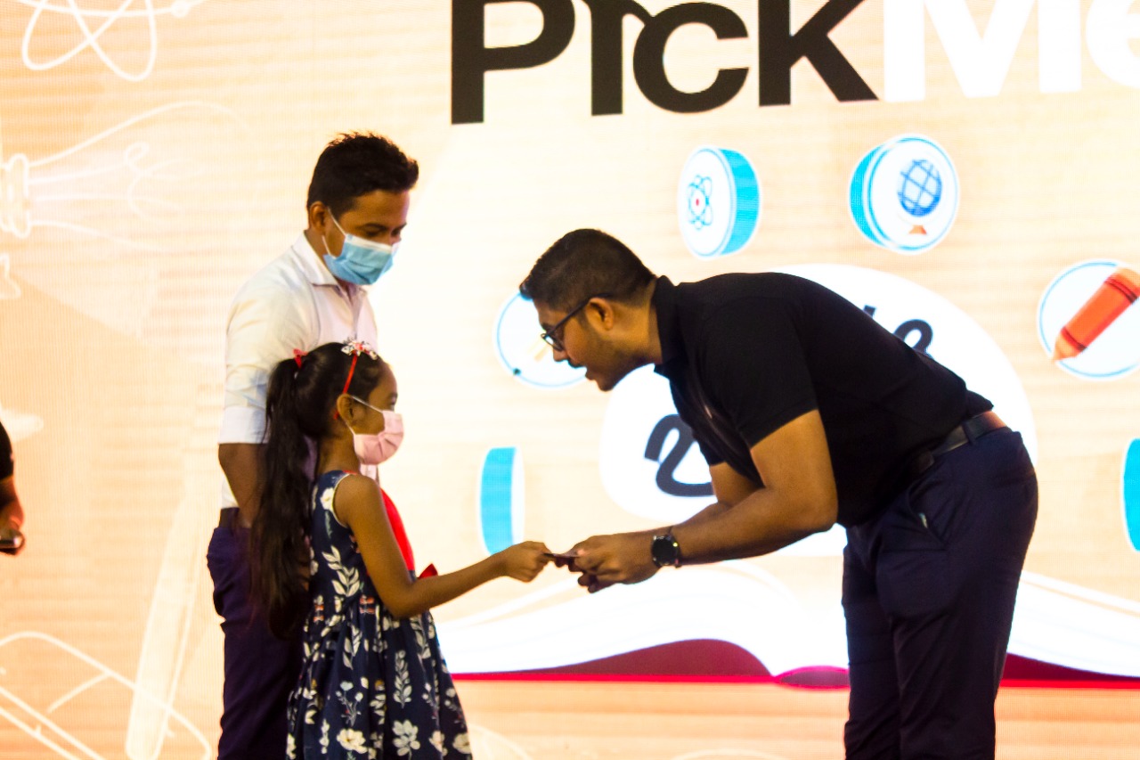PickMe CEO Jiffry Zulfer giving a voucher to a child of a PickMe driver being awarded for loyalty.